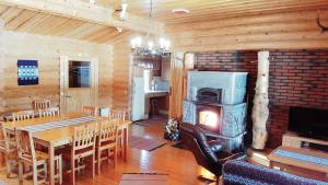 ein Esszimmer mit einem Tisch und einem Holzofen in der Unterkunft Loma-Pälsilä lakeside villa in Kuhmoinen