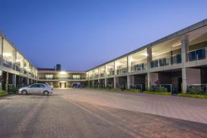 een auto geparkeerd voor een groot gebouw bij Fallsway Suites in Lusaka