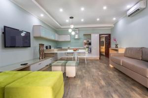een woonkamer met een bank en een tafel en een keuken bij Fallsway Suites in Lusaka