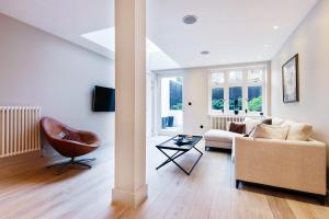 a living room with a couch and a chair at Home Sweet Hampstead Heath in London