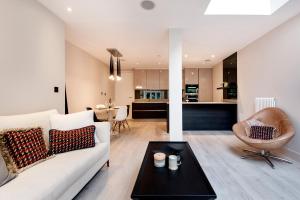 uma sala de estar com um sofá branco e uma mesa em Home Sweet Hampstead Heath em Londres