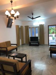 ein Wohnzimmer mit einem Sofa und einem Flachbild-TV in der Unterkunft Sannidhi Home stay in Guruvāyūr