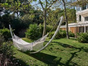 a hammock in a garden in a yard at Ekies All Senses Resort, a Member of Design Hotels in Vourvourou