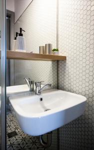 a bathroom with a white sink and a mirror at Old Town Courtyard Apartment with private parking in Cluj-Napoca