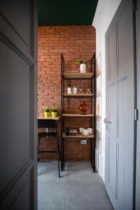 a hallway with a brick wall and a table with plants at Old Town Courtyard Apartment with private parking in Cluj-Napoca