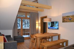 ein Wohnzimmer mit einem Holztisch und einem Esszimmer in der Unterkunft Residence Post in Pec pod Sněžkou