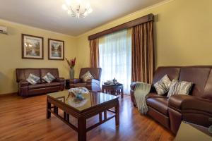 a living room with leather couches and a coffee table at Fallsway Apartments - Burley Court in Lusaka