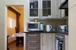a kitchen with white cabinets and a microwave oven at Fallsway Apartments - Burley Court in Lusaka