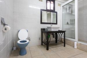 a bathroom with a toilet and a sink and a mirror at Fallsway Apartments - Louden Court in Lusaka
