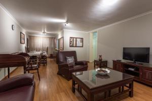 a living room with furniture and a flat screen tv at Fallsway Apartments - Louden Court in Lusaka