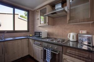 a kitchen with a sink and a stove top oven at Fallsway Apartments - Louden Court in Lusaka