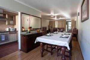 a dining room and kitchen with a table and chairs at Fallsway Apartments - Louden Court in Lusaka