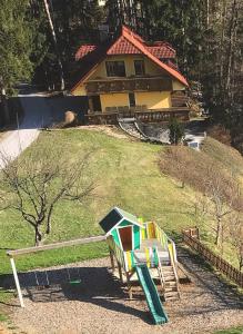 un parque infantil frente a una casa en Country House Apat, en Šoštanj