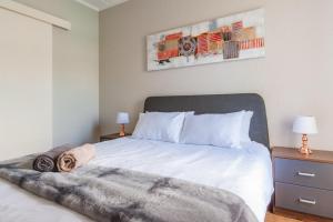 Un dormitorio con una gran cama blanca con dos lámparas. en Alimama Spaces: Manson's Bedford Haven, en Johannesburgo 7 fotos más