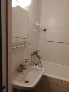 y baño con lavabo, espejo y bañera. en Ivalo Apartment, en Ivalo