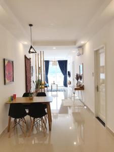 a dining room and living room with a table and chairs at Căn hộ Nghỉ Dưỡng Aparment Melody Vũng Tàu - Tomorrow Homestay 1 in Vung Tau