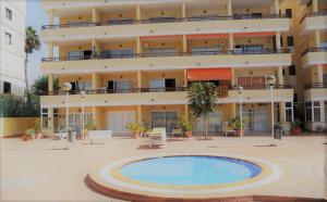 a building with a swimming pool in front of a building at Cosy Corner Playa del Inglés in Playa del Ingles