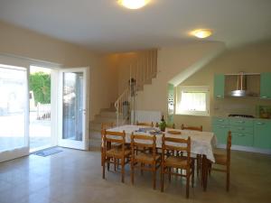 a dining room with a table and chairs and a staircase at Villa Ninfea in Crone