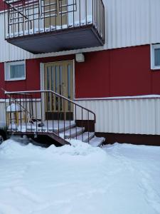 a building with stairs and a door in the snow at Ivalo Apartment in Ivalo