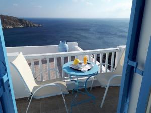 a table and chairs on a balcony with a view of the ocean at Hotel Petradi in Ios Chora