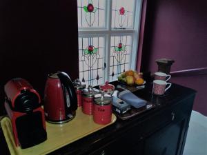 a counter with a coffee maker and fruit on it at Crystal Palace B&B in Crystal Palace +19 photos