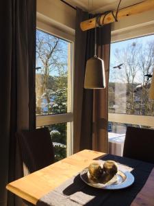 a dining room table with a plate of food and a window at Kleine Harzzeit in Hahnenklee-Bockswiese