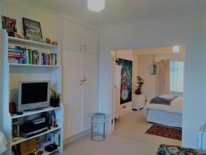 a living room with a television and a bedroom at Crystal Palace B&B in London