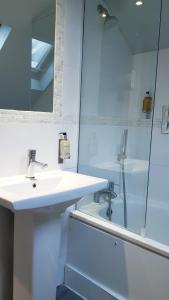 a white bathroom with a sink and a shower at Rushmore Hotel in London