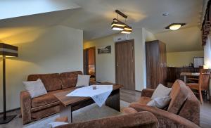 a living room with a couch and a table at Pensjonat Szajna Spa in Rymanów-Zdrój