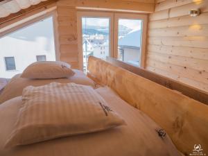 two beds in a room with a large window at Bergkranc Hotel & Resort in Pale