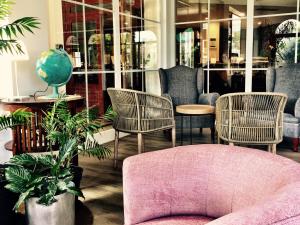 a room with chairs and a pink couch and a table at Hotel Vista Odin in Playa de Palma