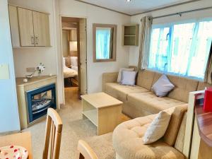a living room filled with furniture and a fireplace at Heacham Gold Caravan in Hunstanton