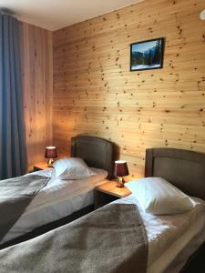 リストヴャンカにあるGuesthouse BAIKAL CEDARのベッド2台 木製の壁の部屋