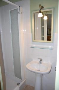 a bathroom with a sink and a shower with a mirror at Clos de l'Arthonnet in Flavignac