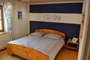 een slaapkamer met een houten bed met een bord aan de muur bij Ferien bei Freunden im Holzhaus in Monschau