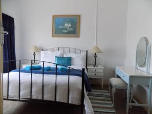 a bedroom with a bed and a desk and a mirror at Sutherland Guest House in Sutherland