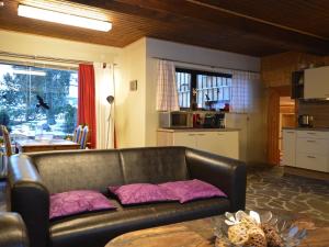 een woonkamer met een leren bank en een tafel bij Spacious Eifel Escape in Manderscheid