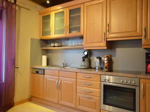 a kitchen with wooden cabinets and a sink at Großes Ferienhaus fuer 8 Personen, Manderscheid in Manderscheid +38 photos