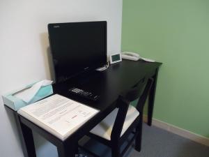 a desk with a computer monitor and a chair at Shin-Okubo City Hotel in Tokyo