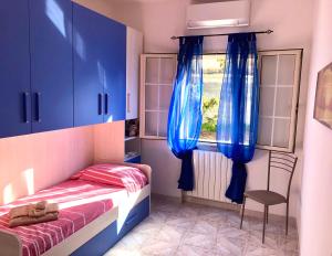 a bedroom with a bed and a window with blue cabinets at Casa Vacanze Dolce Hibiscus in Olbia