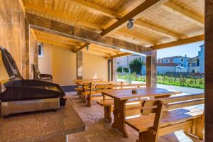 a patio with wooden tables and benches and a grill at Dragan K3 in Medulin +41 photos