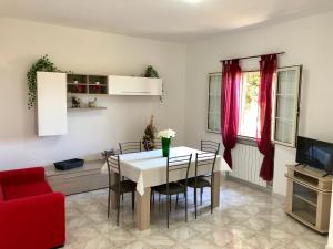 uma sala de jantar com uma mesa branca e uma cadeira vermelha em Casa Vacanze Dolce Hibiscus em Olbia