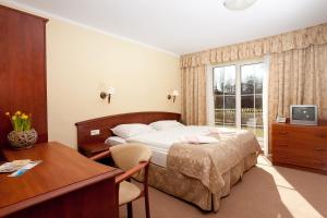 pokój hotelowy z łóżkiem, biurkiem i oknem w obiekcie JANTAR-SPA Kompleks Wypoczynkowo-Rehabilitacyjny w mieście Niechorze +37 zdjęć