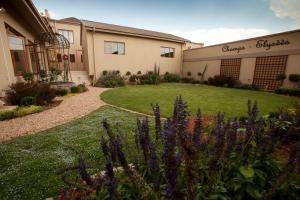 a garden in front of a house with purple flowers at Le Grand Chateau Hotel in Parys
