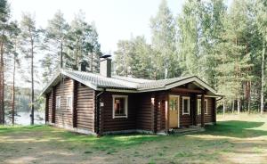 a log cabin in the woods with trees at Loma-Pälsilä lakeside villa in Kuhmoinen +19 photos