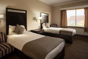 a hotel room with two beds and a window at Wessex Hotel in Street