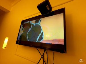 einen Flachbild-TV, der an einer Wand hängt in der Unterkunft Feliz Arambol in Arambol