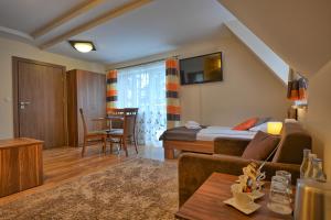 a hotel room with a bed and a living room at Pensjonat Szajna Spa in Rymanów-Zdrój +29 photos