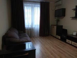 a living room with a couch and a large window at Apartment on Sobornaya street in Rivne
