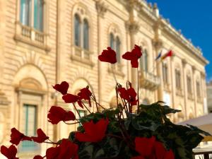 a bouquet of red flowers in front of a building at Scicli Albergo Diffuso in Scicli